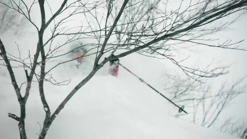 A skier turns through the snow while descending down the hill
