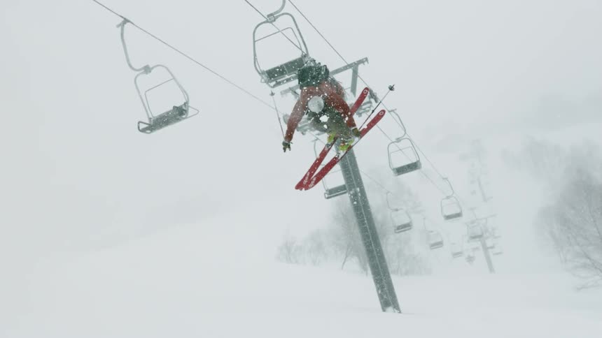 A skier does a 360 spin under a ski lift