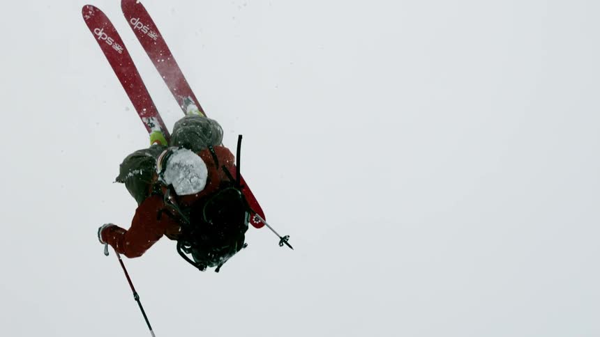 A skier flips through the air in a storm