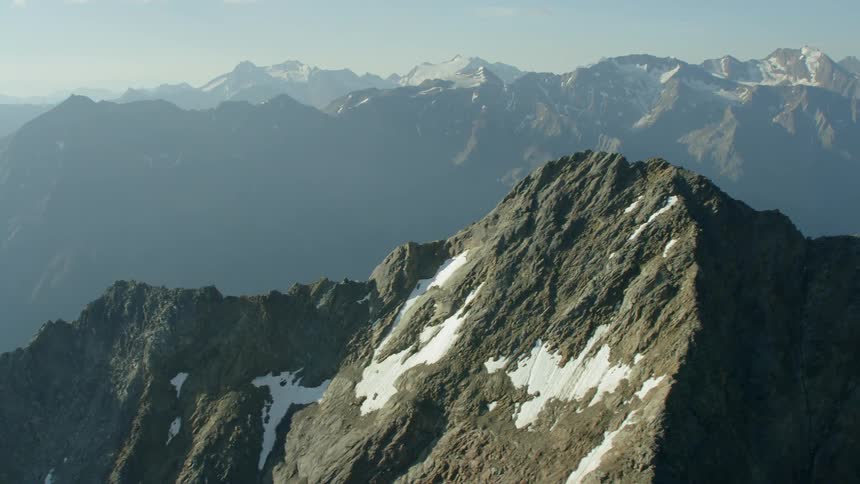 A snowy mountain peak is shown on a sunny day
