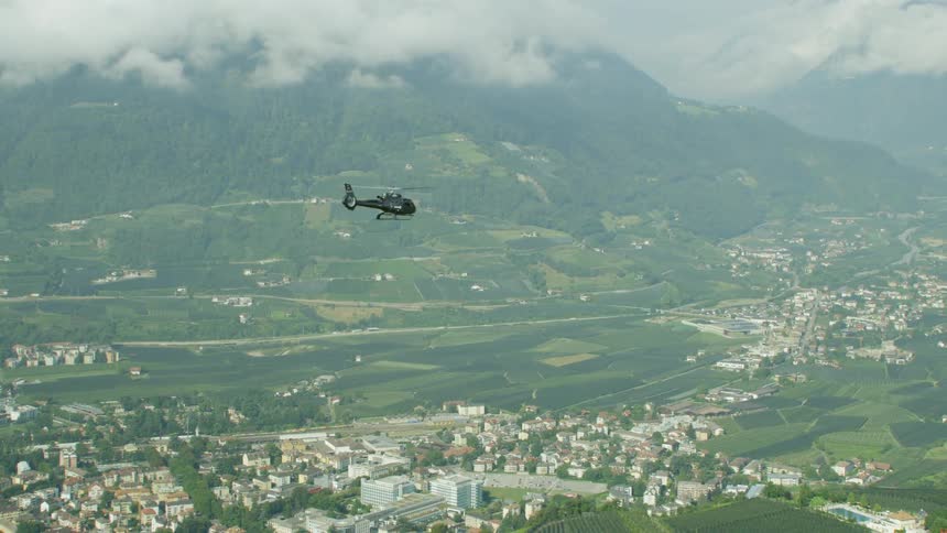 A helicopter flies in the sky above a town