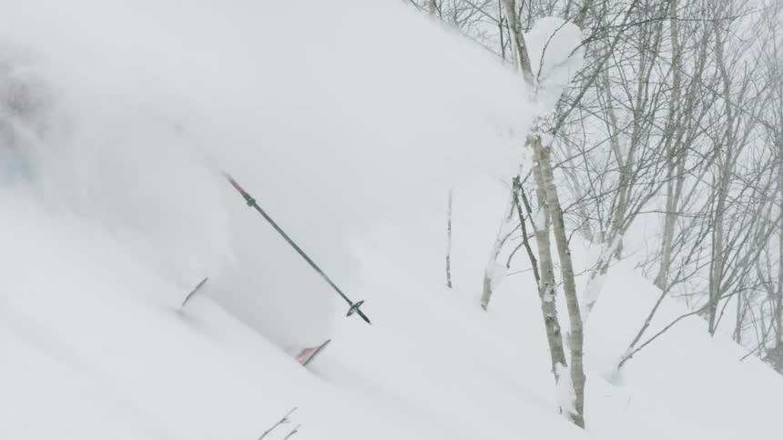 A skier turns through deep snow on a slope