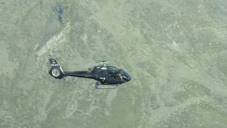 A helicopter flies high in the sky