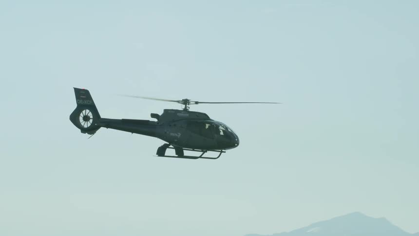 A helicopter flies high in the sky