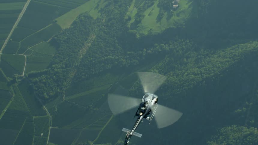 A helicopter flies over a rural area