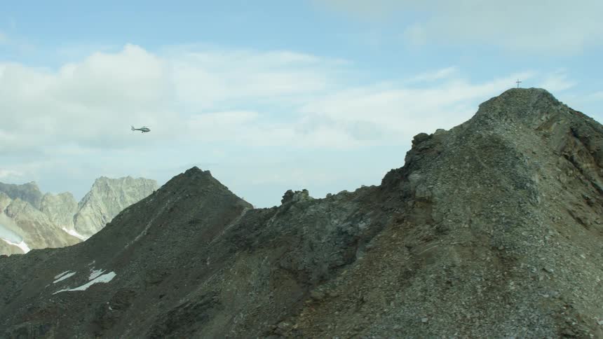 A helicopter flies over mountains