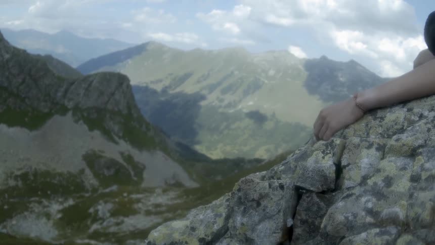 A man lays on a rock cliff