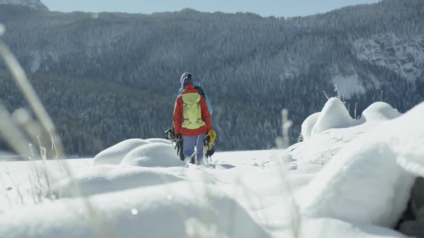 People hike in snowy mountains