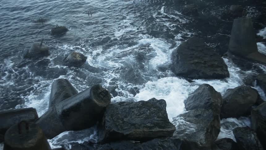 Ocean waves crash into a rocky shore