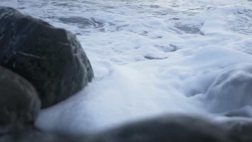 The tide flows onto the beach shore
