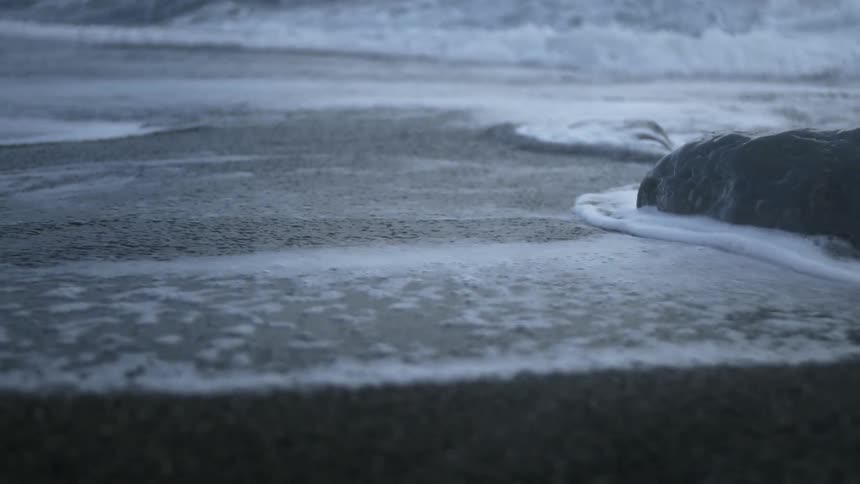 The tide flows onto the beach shore