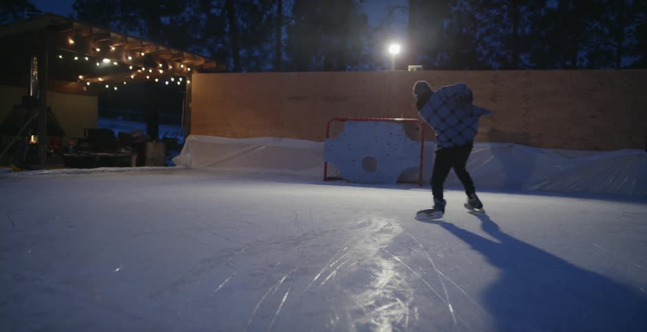 A hockey player skates on an outdoor ice rink
