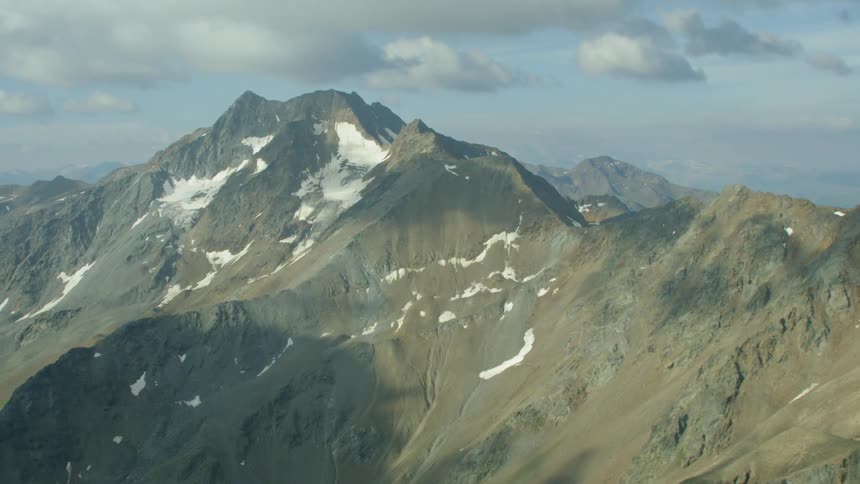 Clouds are hanging above a mountain range during the day