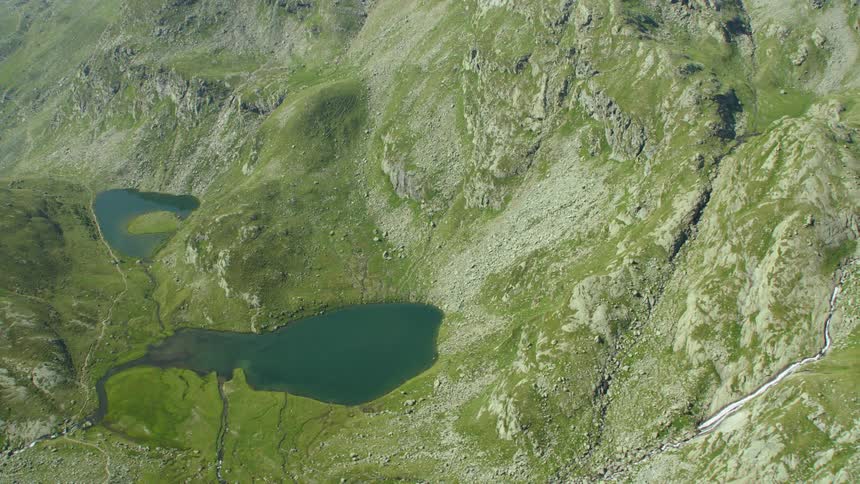 Lakes sitting at the bottom of some green hills