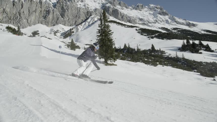 Two people ski together down the slope