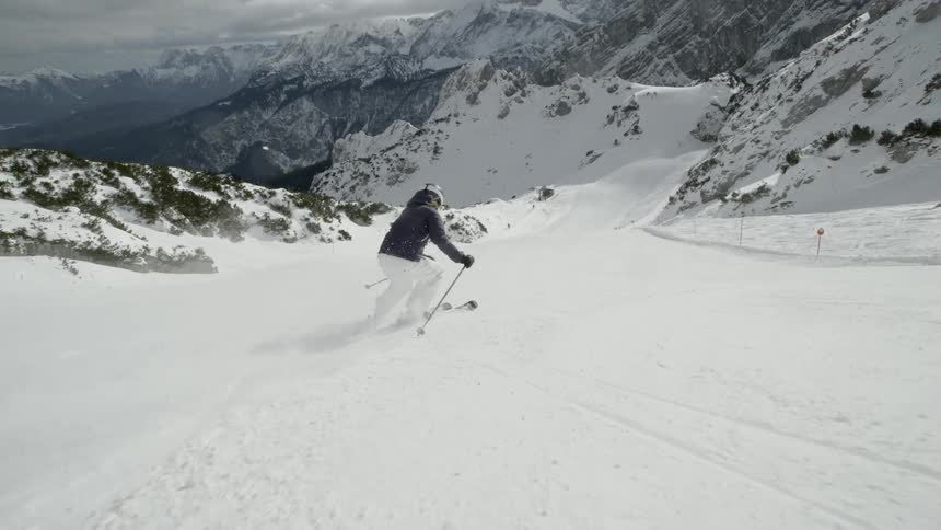 A skier glides down a snowy mountainside