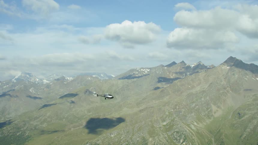Helicopter flies over mountain range