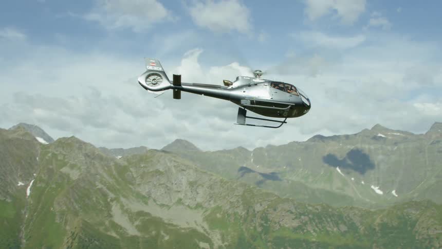 A helicopter flies high in the sky