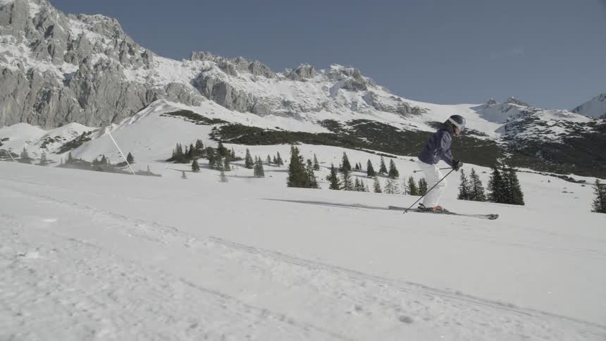 A skier glides down a snowy mountainside