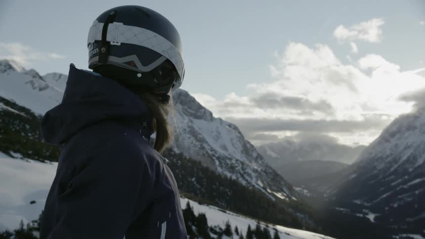 A skier wearing a helmet looks down the slope