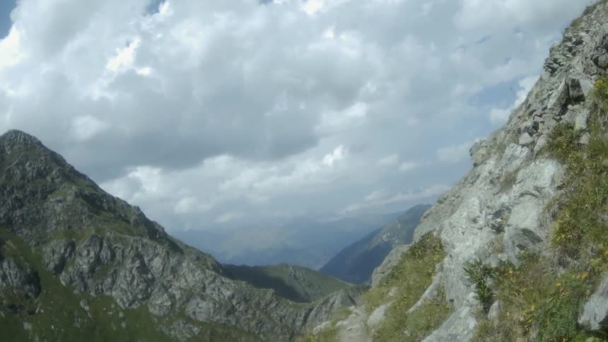 Clouds hang above the tall stone mountains