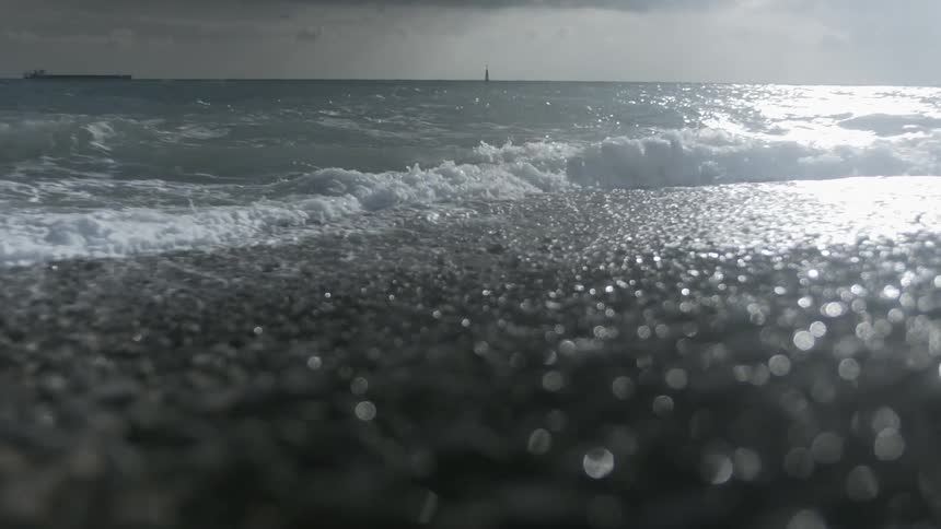 The tide rolling in on the beach on a dark and cloudy day