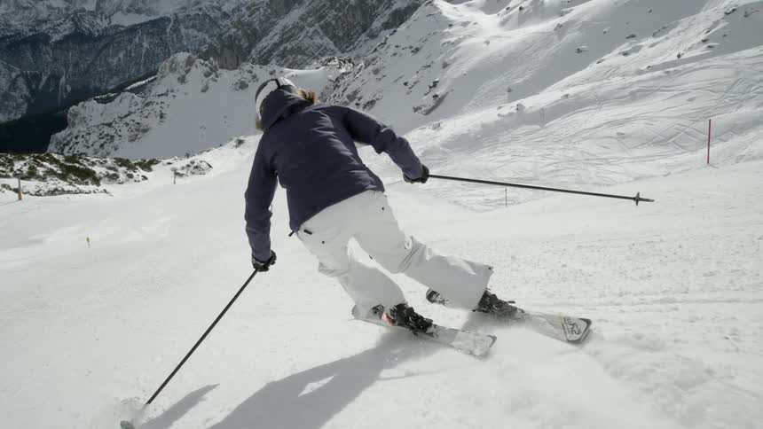 A skier glides down a snowy mountainside