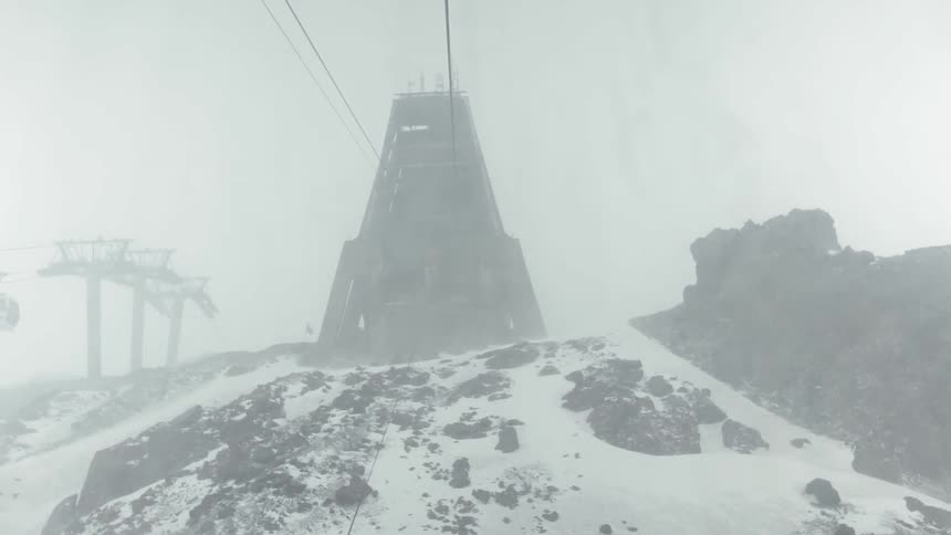 Snow falls rapidly on top of a ski slope