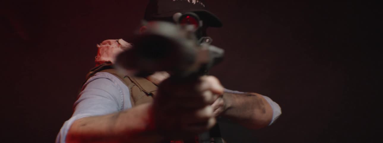 A man is looking down the sights of a sniper rifle