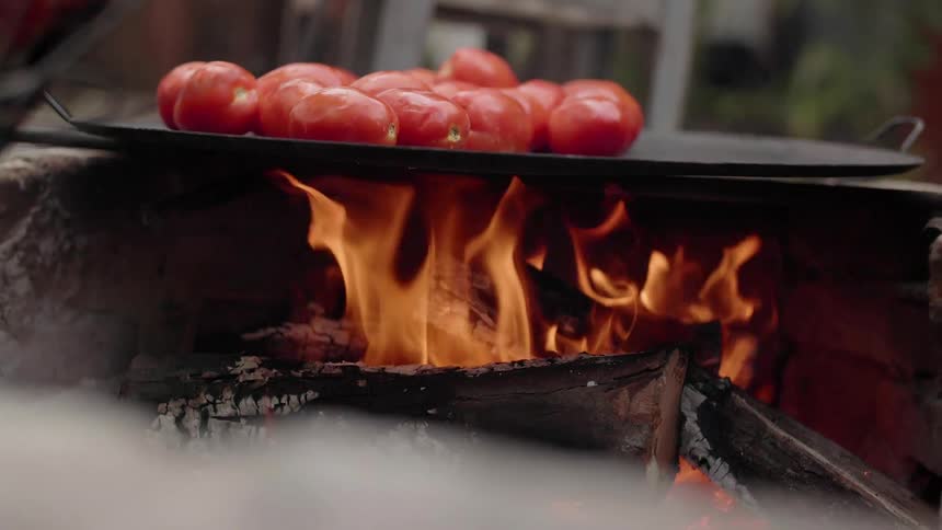 Tomatoes are roasted on an open wood fire