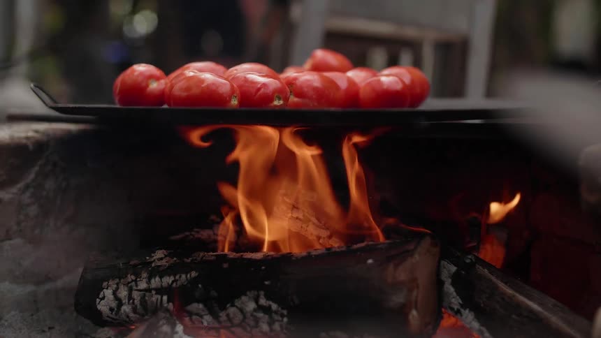 Tomatoes are roasted on an open wood fire