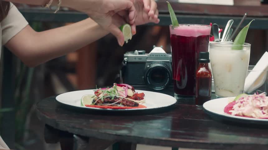 A woman squeezes lime juice on her plate