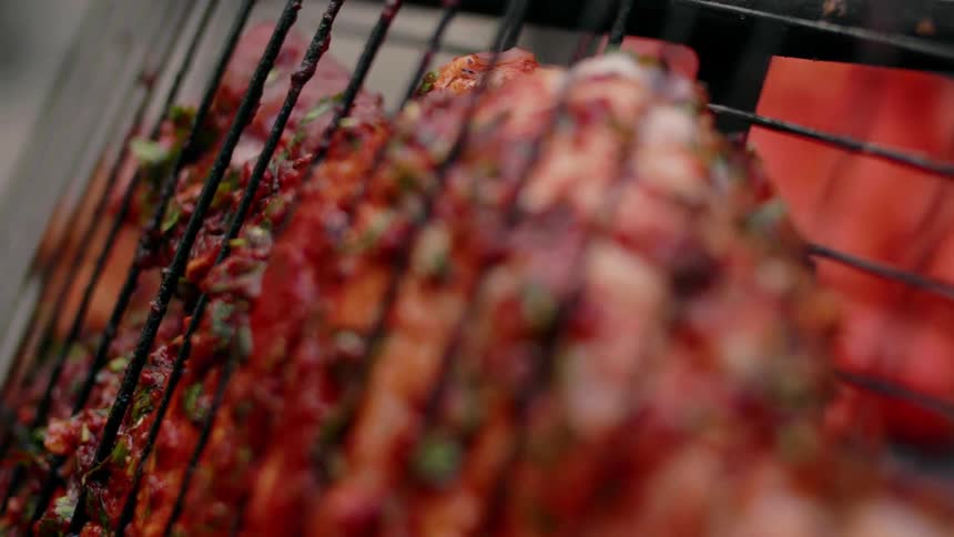 Seasoned meat between to grill racks