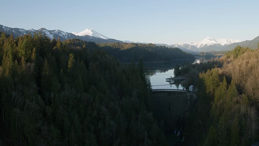 Rapid pullback ascent to show the scale and surroundings of a mountain valley hydroelectric power plant