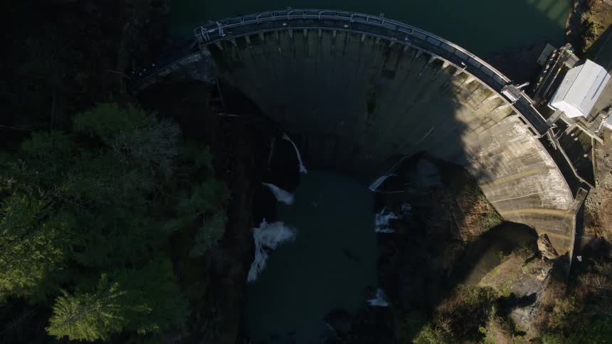 Overhead view of a large hydroelectric dam and deep river valley