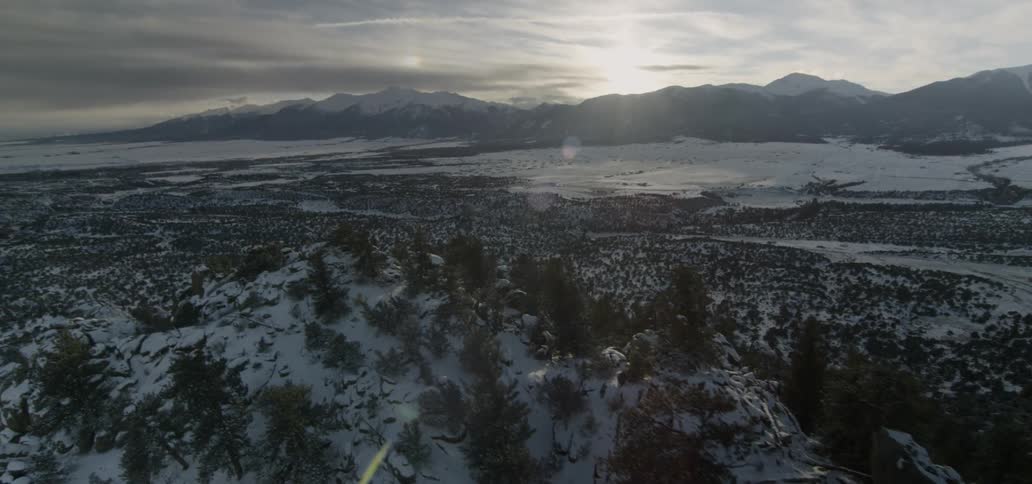 The sun sets over snowy mountains