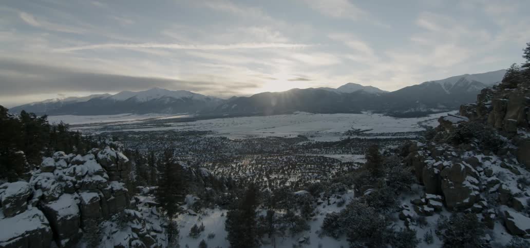 Sunlight shining over a mountain valley on a winter day