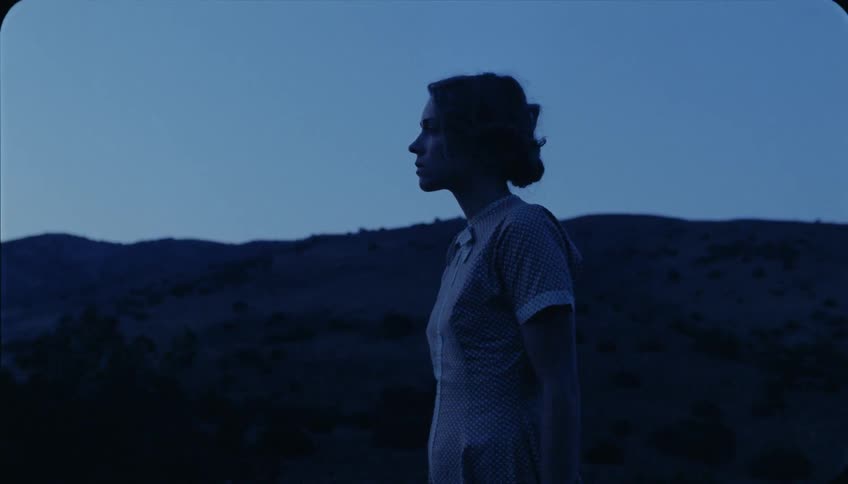 A woman walks in a rural area at dusk