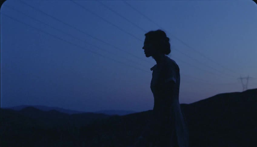 A woman walks outside at dawn