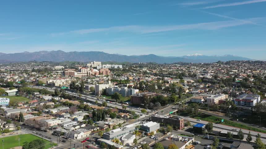 Traffic travels and a freeway and city streets on a sunny day