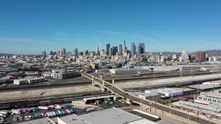 A bridge leads into the city with tall buildings
