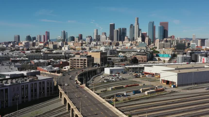 The cars drive into the city on a sunny day