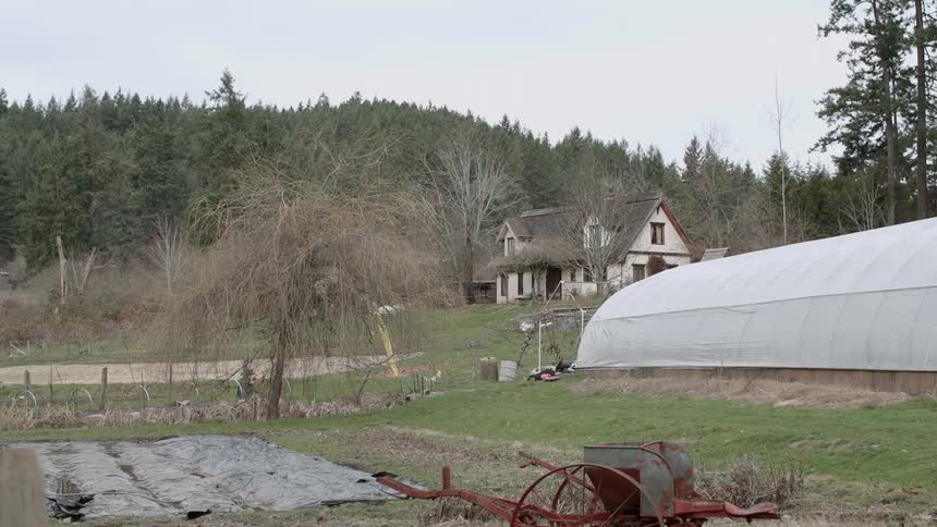 A greenhouse sits on a rural farm