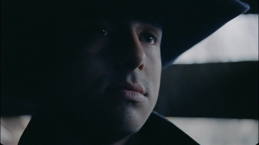 Man wearing a cowboy hat stares ahead