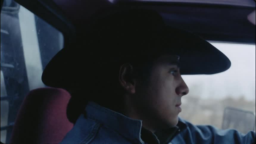 A cowboy drives a truck