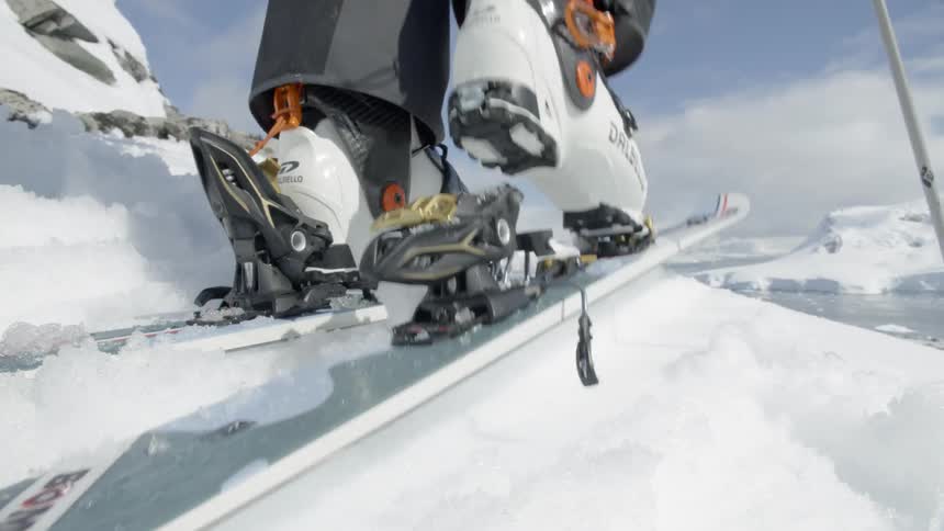 A skier snaps their boot into a ski