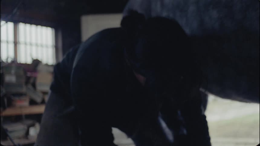 A person is working in the dark barn