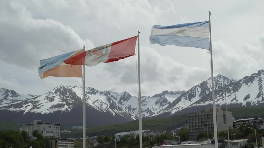 Several flags waving in strong winds on a cloudy day