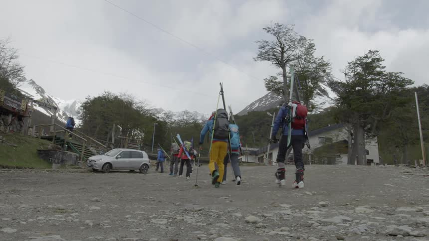 Skiers walk in the mountains of south america while it snows