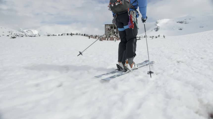 A skier glides over snow in the mountains